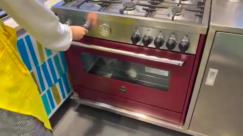 Student placing ricotta coffee cake in the oven for La Germania Student Recipes